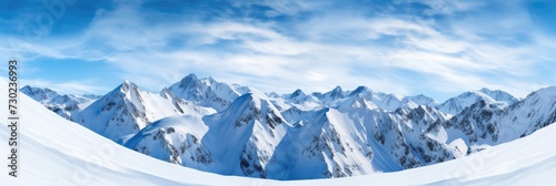 Landscape of a winter mountain range covered in snow with a bright blue sky. © brillianata