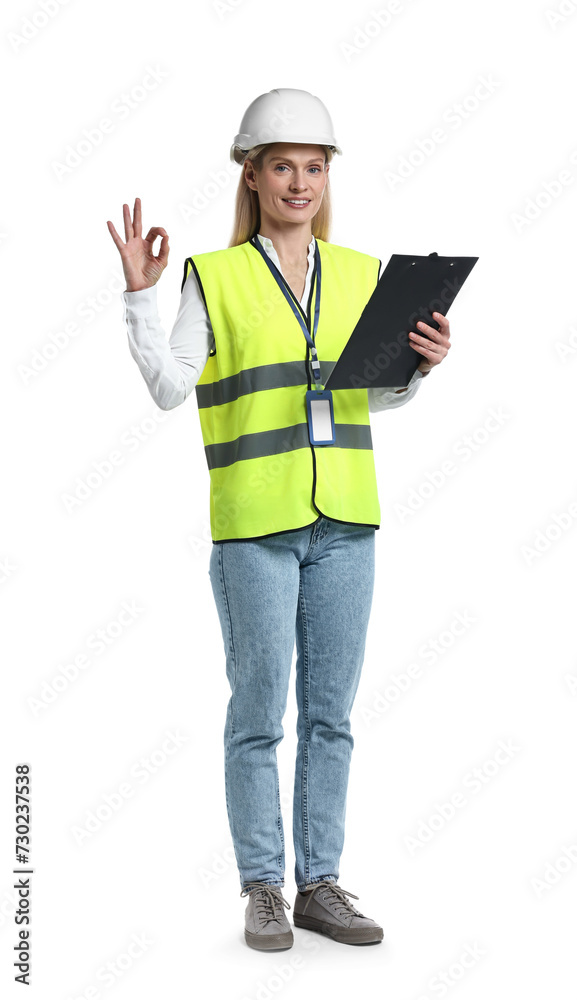 Engineer in hard hat holding clipboard and showing ok gesture on white background Engineer in hard hat holding clipboard and showing ok gesture on white background
