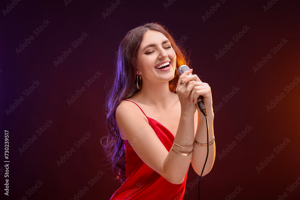 Emotional woman with microphone singing in color lights Emotional woman with microphone singing in color lights