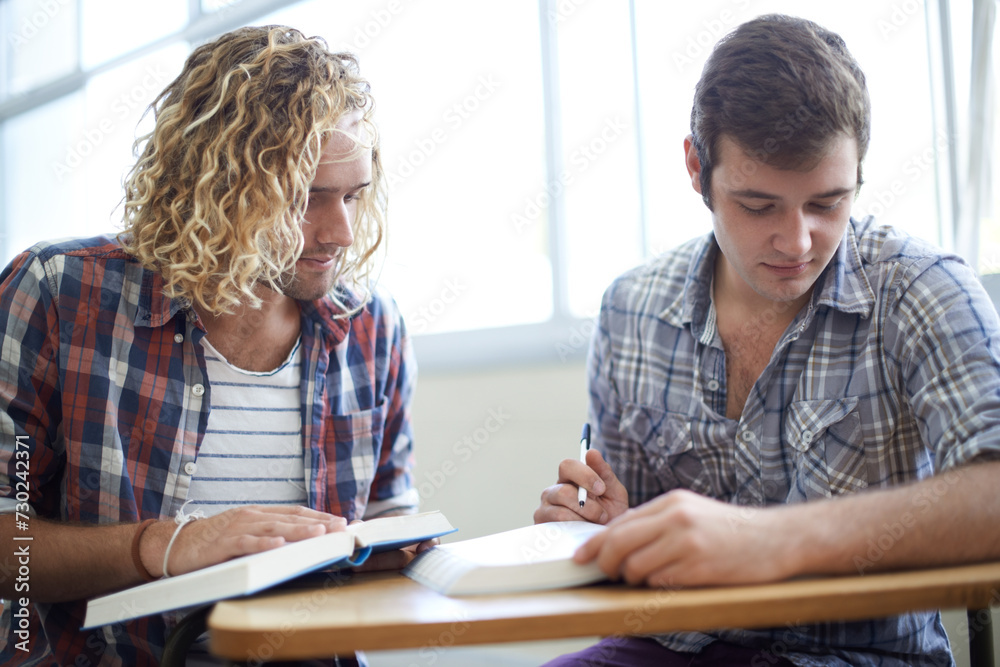 Obraz premium Men, students and reading textbook in college with teamwork for education assignment, project or research. Male people, friends and group studying in university for lecture or learning, notes or exam
