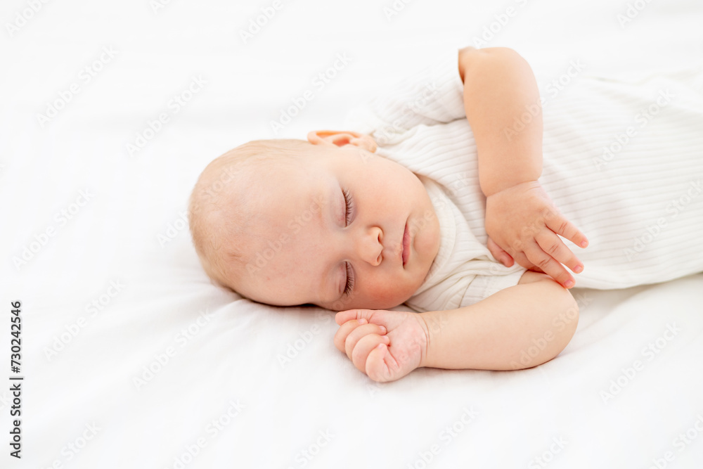 cute little newborn baby sleeps with his hand folded under his cheek, sweet healthy baby sleep in a white crib, a place for text cute little newborn baby sleeps with his hand folded under his cheek, sweet healthy baby sleep in a white crib, a place for text