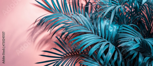 Teal-colored palm leaves artfully contrast against a pink background for a tropical feel