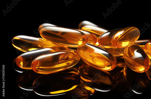 Two Omega 3 capsules isolated on a black background and many other capsules on a blurred background. Fish oil capsules close-up. The concept of healthy eating and healthy food supplements