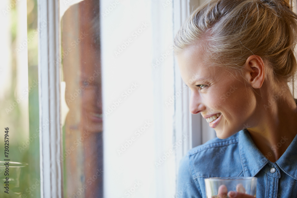 Thinking, smile and woman with coffee in a house for peaceful, reflection or moment at home. Remember, face and female person with happy memory, tea or enjoying me time or weekend at apartment window