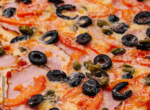 Pizza with ham, parmesan cheese and olives