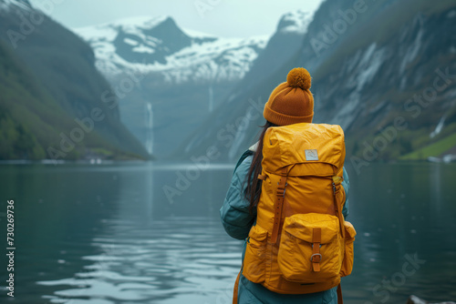 a woman in a yellow backpack looks out at the lake in Norway. Background image. Created with Generative AI technology