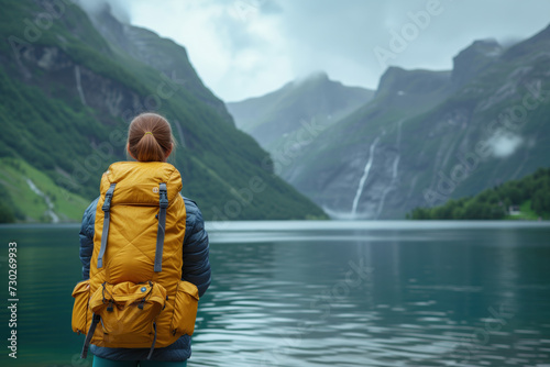 a woman in a yellow backpack looks out at the lake in Norway. Background image. Created with Generative AI technology