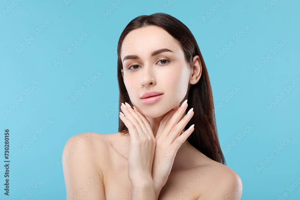 Portrait of beautiful young woman on light blue background