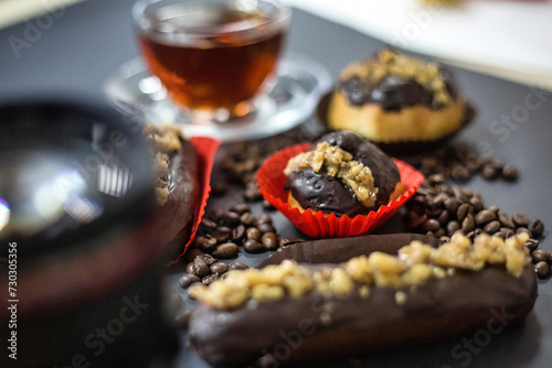 Chocolate Covered Donuts on Table Next to Cup of Tea