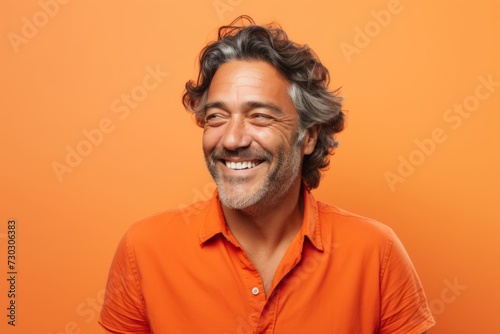 Portrait of a happy mature man in orange shirt on orange background