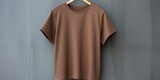 Brown t shirt is seen against a gray wall