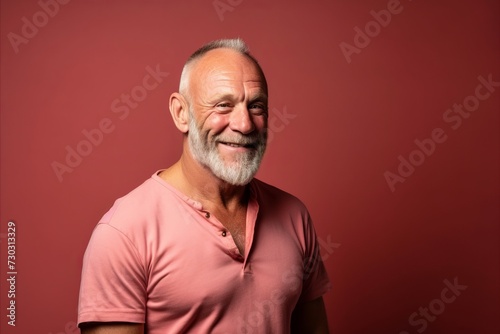 Portrait of a senior man in a pink t-shirt.