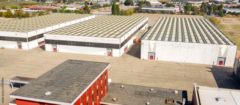 Aerial view on the entrance of an industrial container. The shed is white and gray and used as a warehouse. 