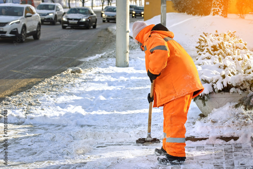 Street cleaner removing ice with steel razor scraper on sidewalk at bus stop. Clean and remove ice and snow with icebreaker tool. Ice removal work; clear paving slabs in cold winter day Street cleaner removing ice with steel razor scraper on sidewalk at bus stop. Clean and remove ice and snow with icebreaker tool. Ice removal work; clear paving slabs in cold winter day