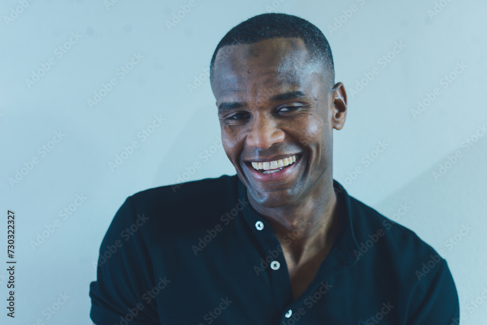 young black african american man wearing a black shirt smiles warmly as he poses for the camera. young black african american man wearing a black shirt smiles warmly as he poses for the camera.