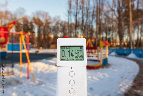 Measuring radiation using a modern dosimeter radiometer. Monitoring dangerous ionizing radiation outdoors in a city park or playground. Radiation safety control. Soft selective focus photo