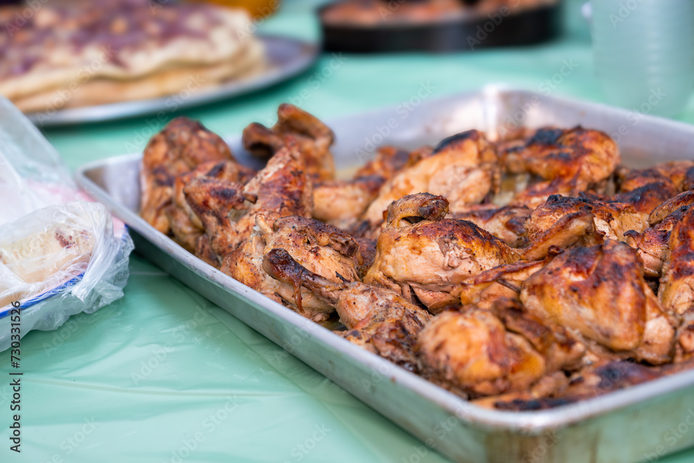 grilled Chicken tray ready to be eaten with people hands and musakhan bread