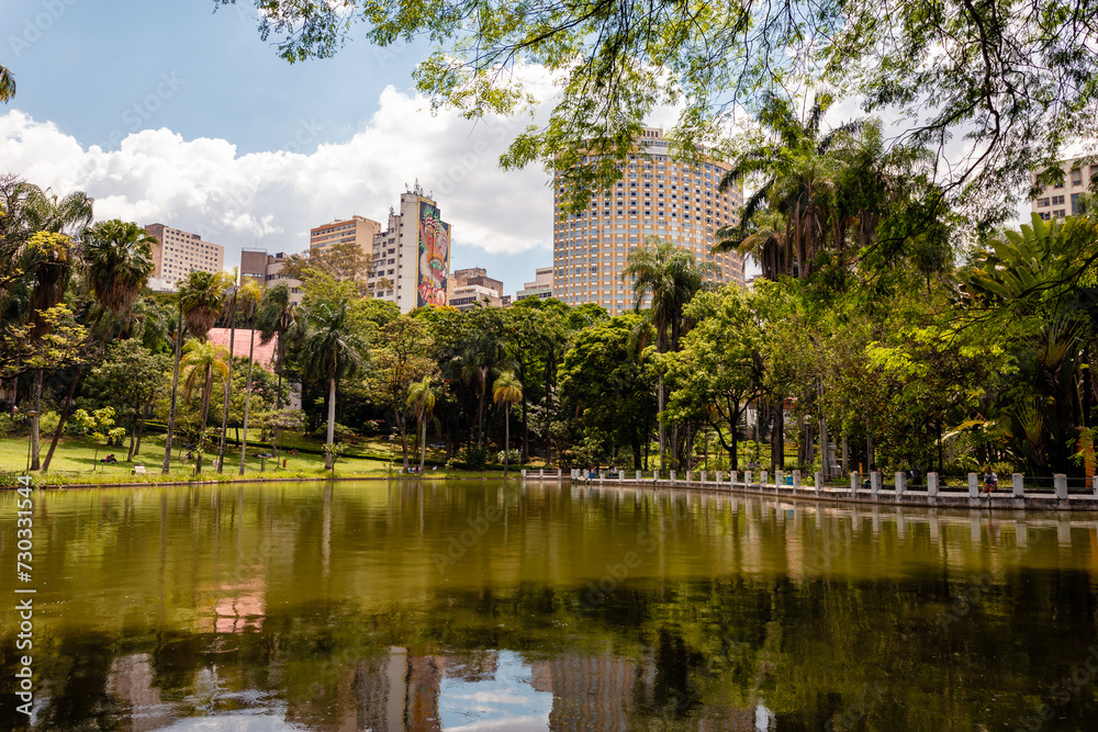 Belo Horizonte Municipal Park, during a beautiful sunny day with the sky's clouds reflected in the lake.