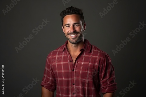Portrait of a handsome man smiling at the camera on a dark background