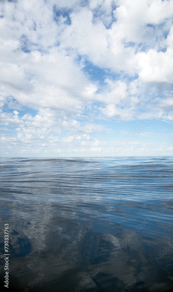 Fototapeta premium Sky over water in open sea and clouds, calm with space for text
