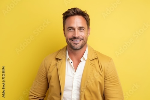 Portrait of a handsome man smiling at the camera over yellow background
