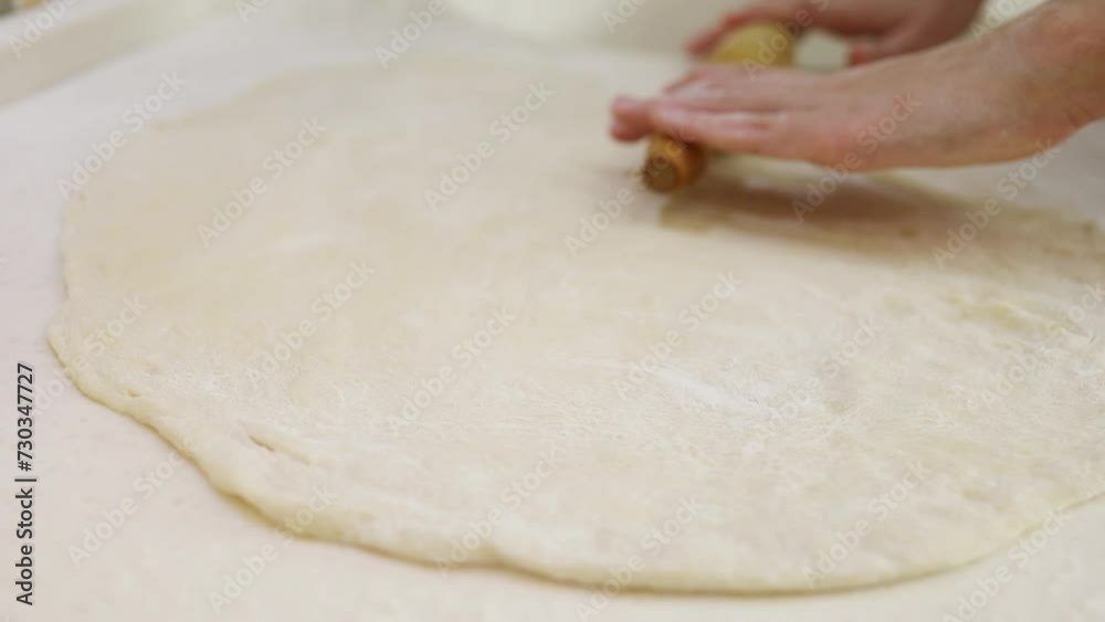 Child hands roll dough with rolling pin for baking on table Child hands roll dough with rolling pin for baking on table