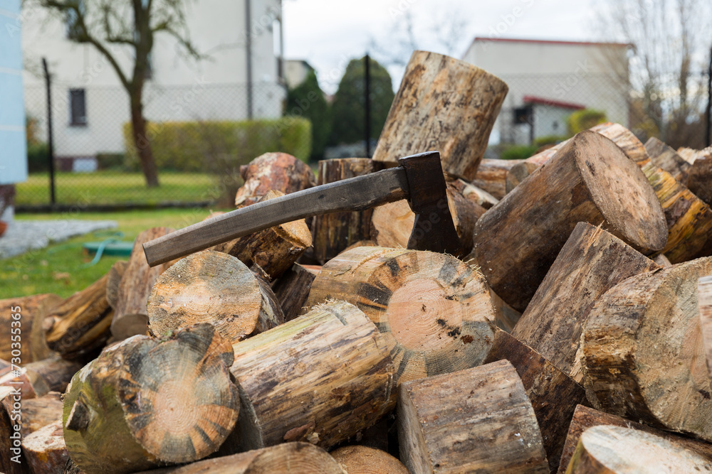 An ax for splitting firewood stuck into a stump for chopping wood. An ax for splitting firewood stuck into a stump for chopping wood.