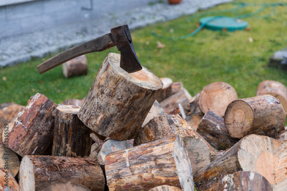 An ax for splitting firewood stuck into a stump for chopping wood. An ax for splitting firewood stuck into a stump for chopping wood.