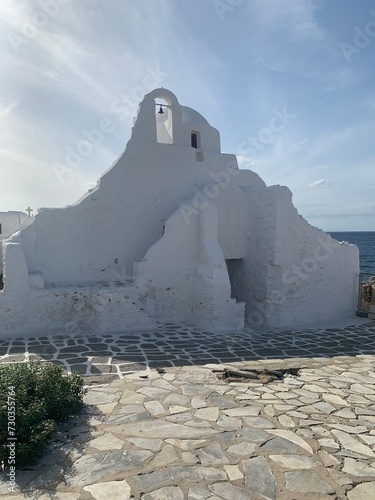 Typical street of greek traditional village with white walls and colorful doors, windows and balconies Sunset on Mykonos Island, Greece, Europe photo