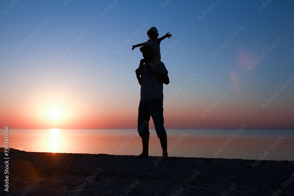 A Happy parent with child by the sea play on nature silhouette travel