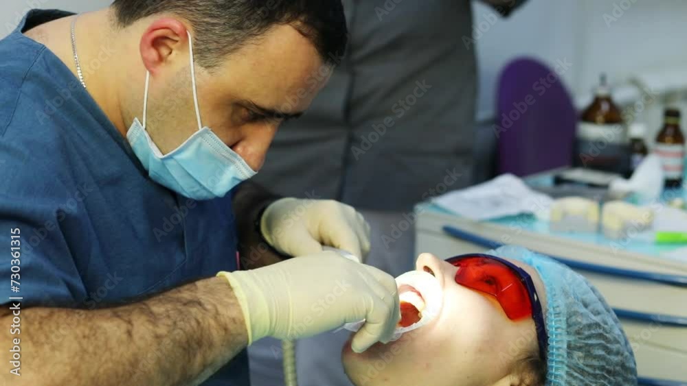 Dentist prepares mouth of woman patient (MR) for treatment in clinic, slow motion Dentist prepares mouth of woman patient (MR) for treatment in clinic, slow motion