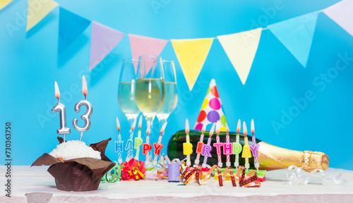 Date of birth with candles and number  13. Anniversary greeting card. Holiday decorations. Happy birthday candles. Multicolored decorations with garland