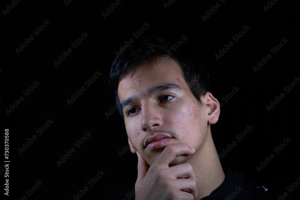 Portrait for teenager with thinking expression in dark and light studio Portrait for teenager with thinking expression in dark and light studio