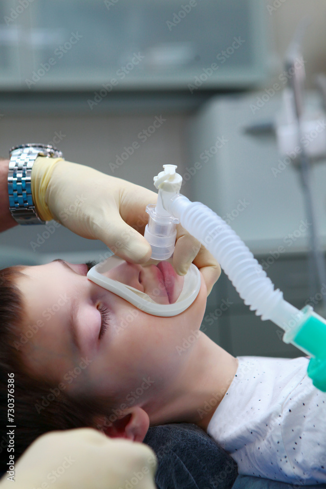 A child with an oxygen mask on his face. Preparing the child for