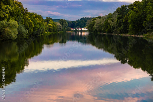 Stausee mit Spiegelung am Abend zur blauen Stunde. Landschaftsfoto mit Wald, Wasser, Häuser und Spiegelung