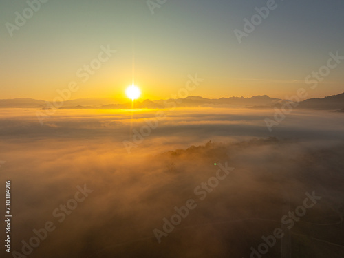 Aerial view scenery beautiful sunrise above the sea of mist in front Thi Lor Su waterfall...There is a golden yellow glow on the horizon caused by the radiant light of the sun...colorful 