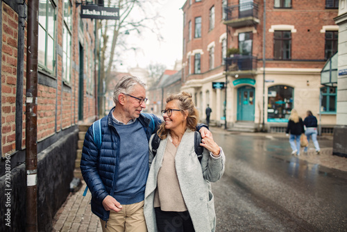 Embraced senior couple walking in the city photo