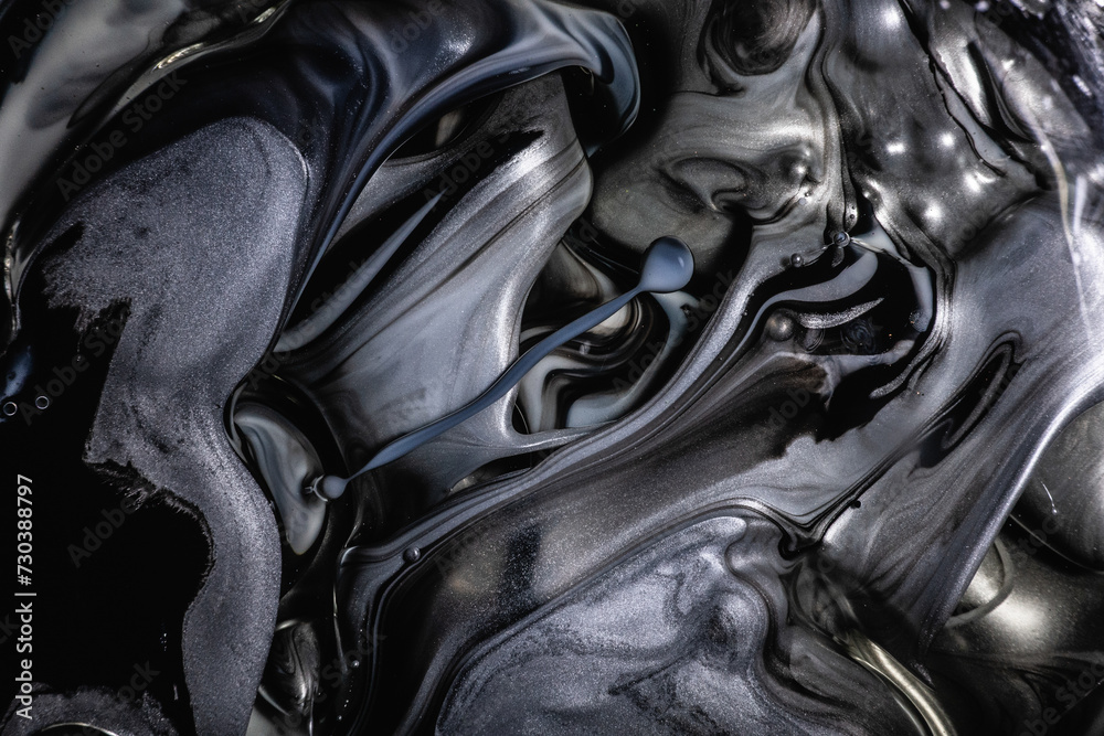 Monochromatic abstract of black and gray swirling inks with subtle bubbles, creating a mysterious and fluid metallic texture