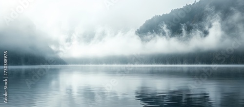 Gorgeous serene lake scenery shrouded in fog