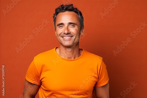 Portrait of a handsome man in orange t-shirt on orange background