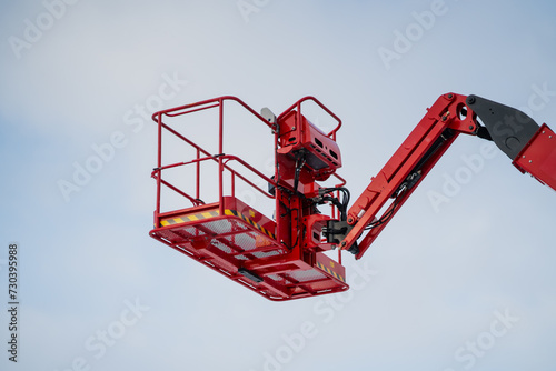 Red telescopic lift platform lifted in the air. Construction equipment close up photo