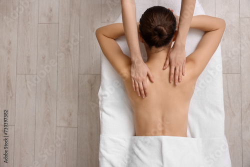 Woman receiving back massage on couch in spa salon, top view. Space for text