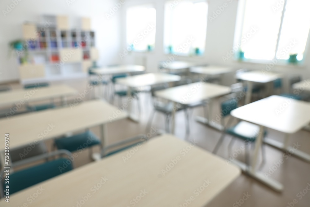 Blurred view of empty school classroom with desks, windows and chairs Blurred view of empty school classroom with desks, windows and chairs