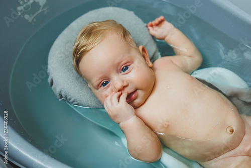 Baby's first baths. Caring for a newborn baby. Bathing a baby in a bathtub. A newborn baby is bathing in the water.