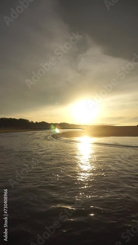 beautiful vertical video view of the sunrise on the beach with small waves, morning natural panorama on Karang Paranje beach, Garut photo