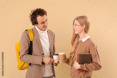 Teenage couple with cups of...