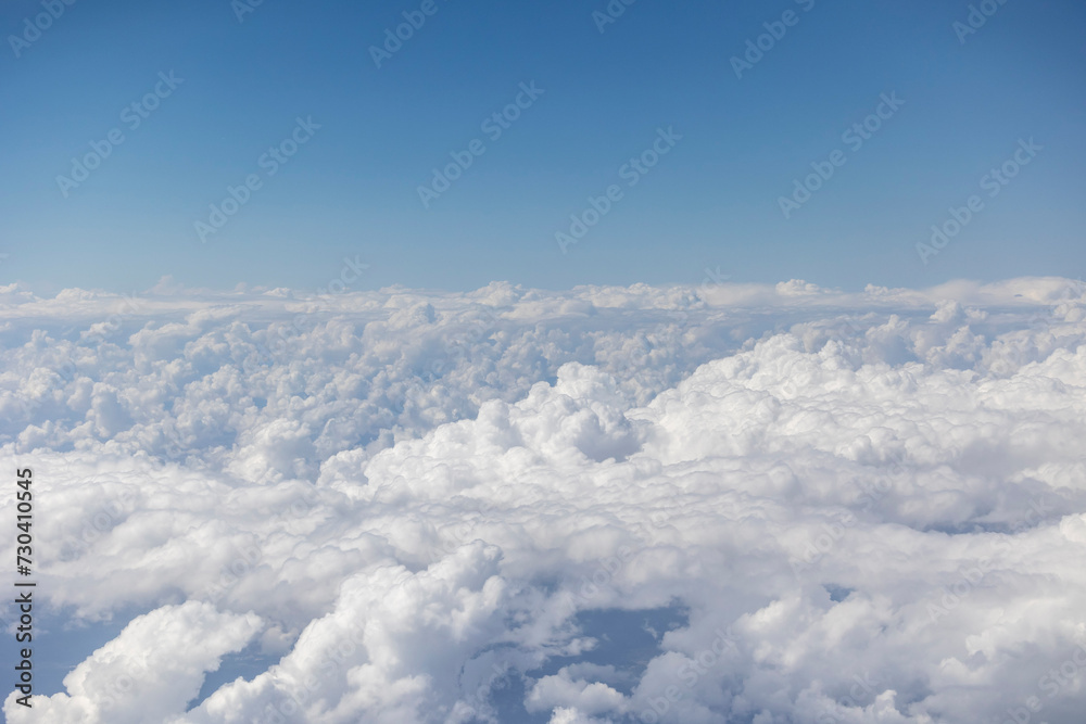 View from the airplane window, clouds, land, and sky View from the airplane window, clouds, land, and sky