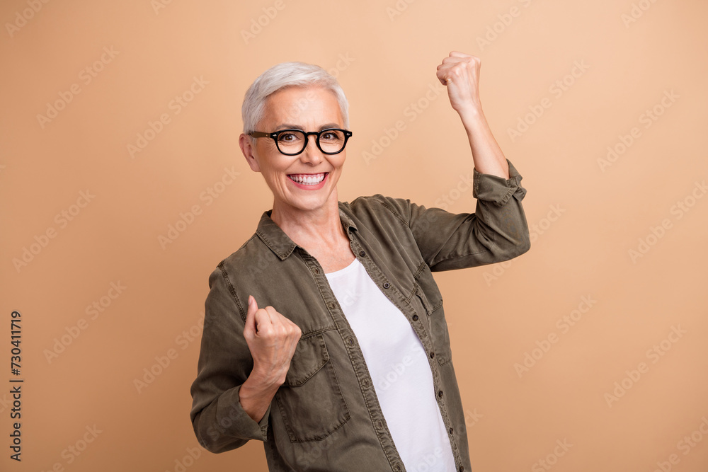 Portrait of crazy ceo manager raised fists up ambitious growth company and salaries winning all competitions over beige color background Portrait of crazy ceo manager raised fists up ambitious growth company and salaries winning all competitions over beige color background