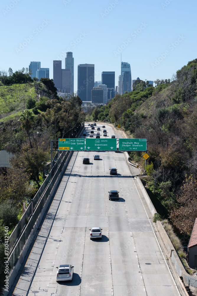 Los Angeles skyline and 110 freeway downtown arrow sign. Vertical view. Los Angeles skyline and 110 freeway downtown arrow sign. Vertical view.