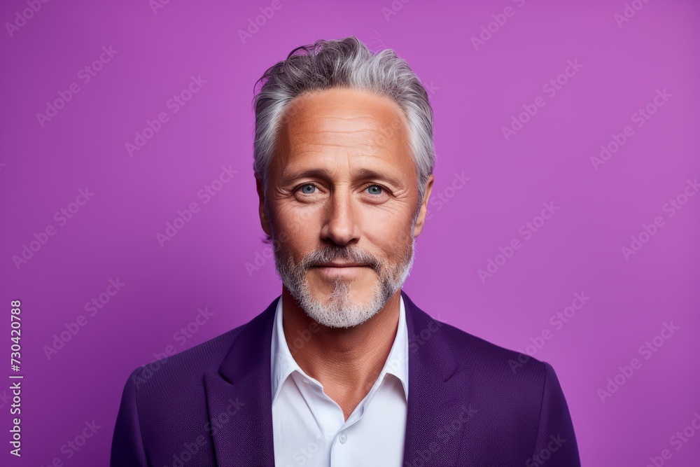 Portrait of handsome mature man with grey hair and beard. Isolated on purple background. Portrait of handsome mature man with grey hair and beard. Isolated on purple background.